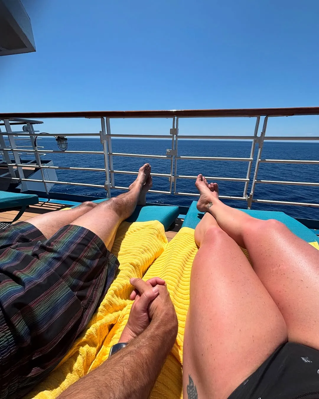 Couple relaxing on cruise ship deck with ocean view